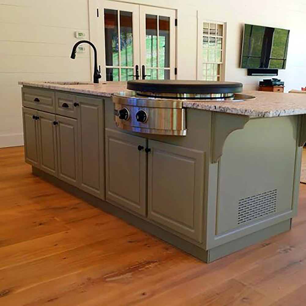 Built-in gas grill with stainless flat top, two knobs, and cabinet door base