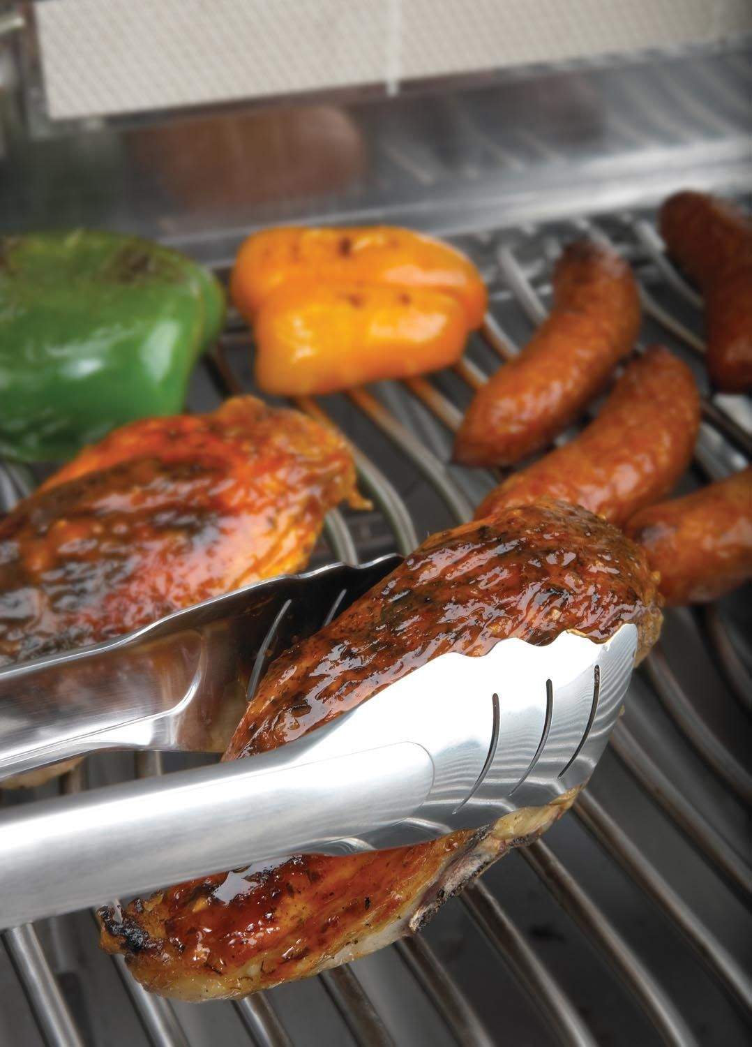 Stainless steel locking tongs gripping grilled sausages on a barbecue grate