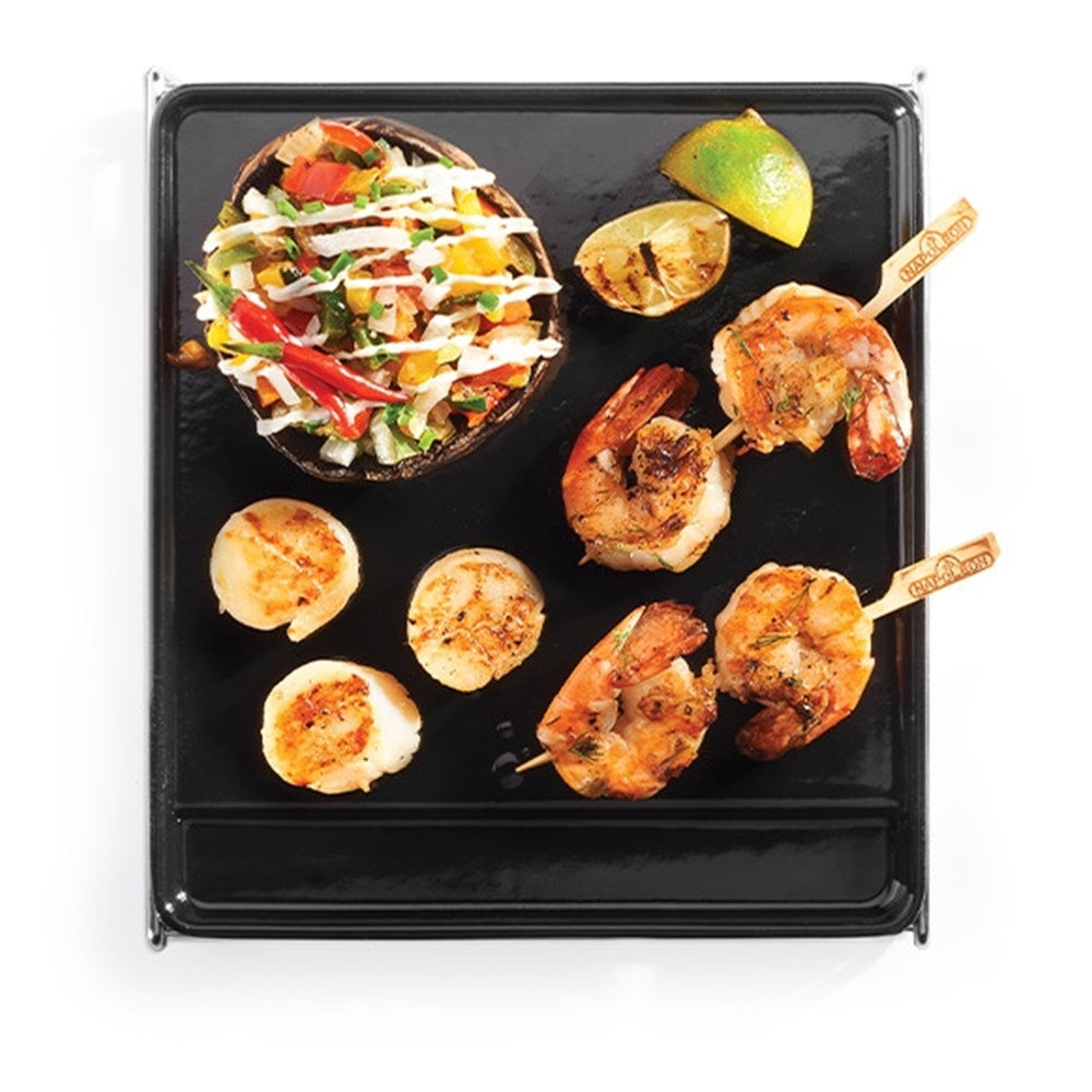 Cast iron griddle with seafood and veggie skewers, black cooking surface, open lid