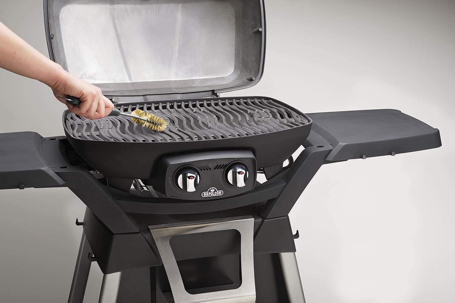 Napoleon grill brush with stainless steel bristles in use on grill grates
