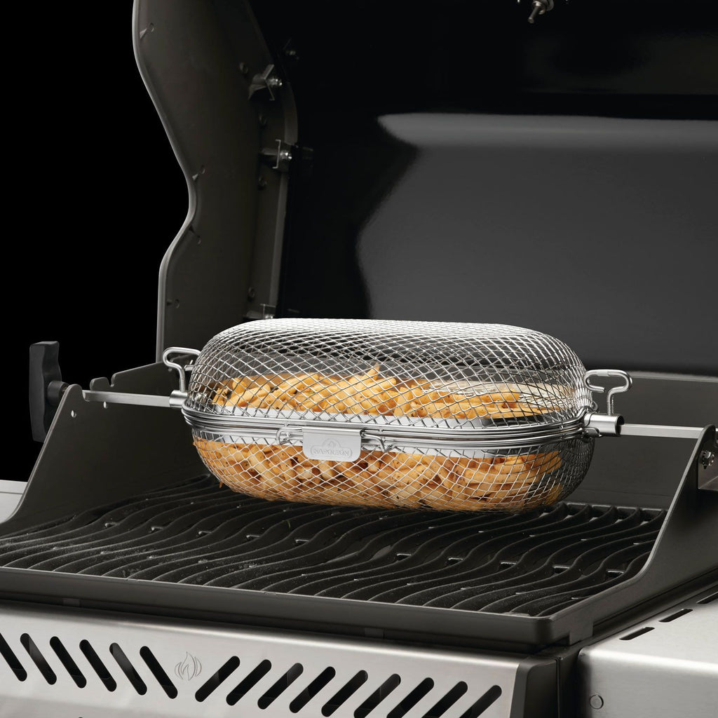 Stainless rotisserie grill basket with wire mesh and side handles on a grill