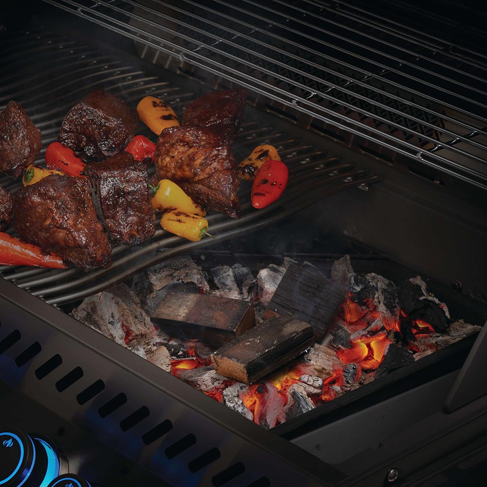 Barrel wood chunks in grill coals, dark charred pieces
