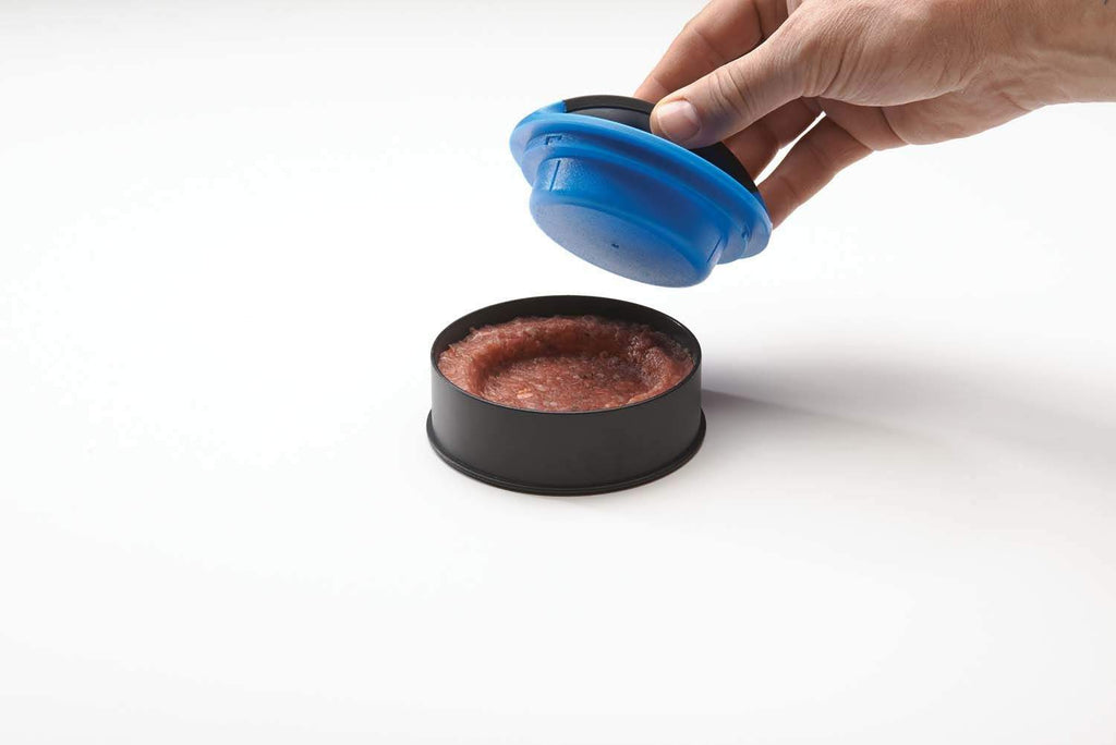 Hand pressing on burger patty using blue top on black round mold