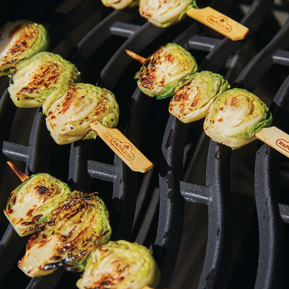 Bamboo skewers with grilled vegetables on a ribbed grill grate