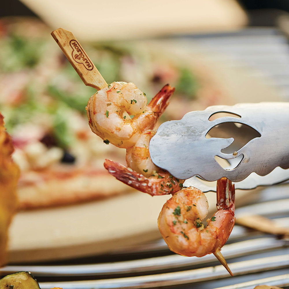 Bamboo skewers with shrimp and a metal serving tool