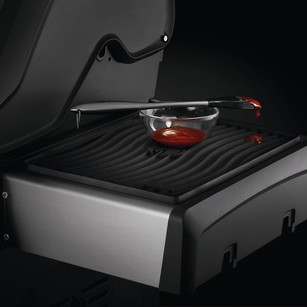 Black ribbed silicone side shelf mat on grill shelf with cookware resting on it