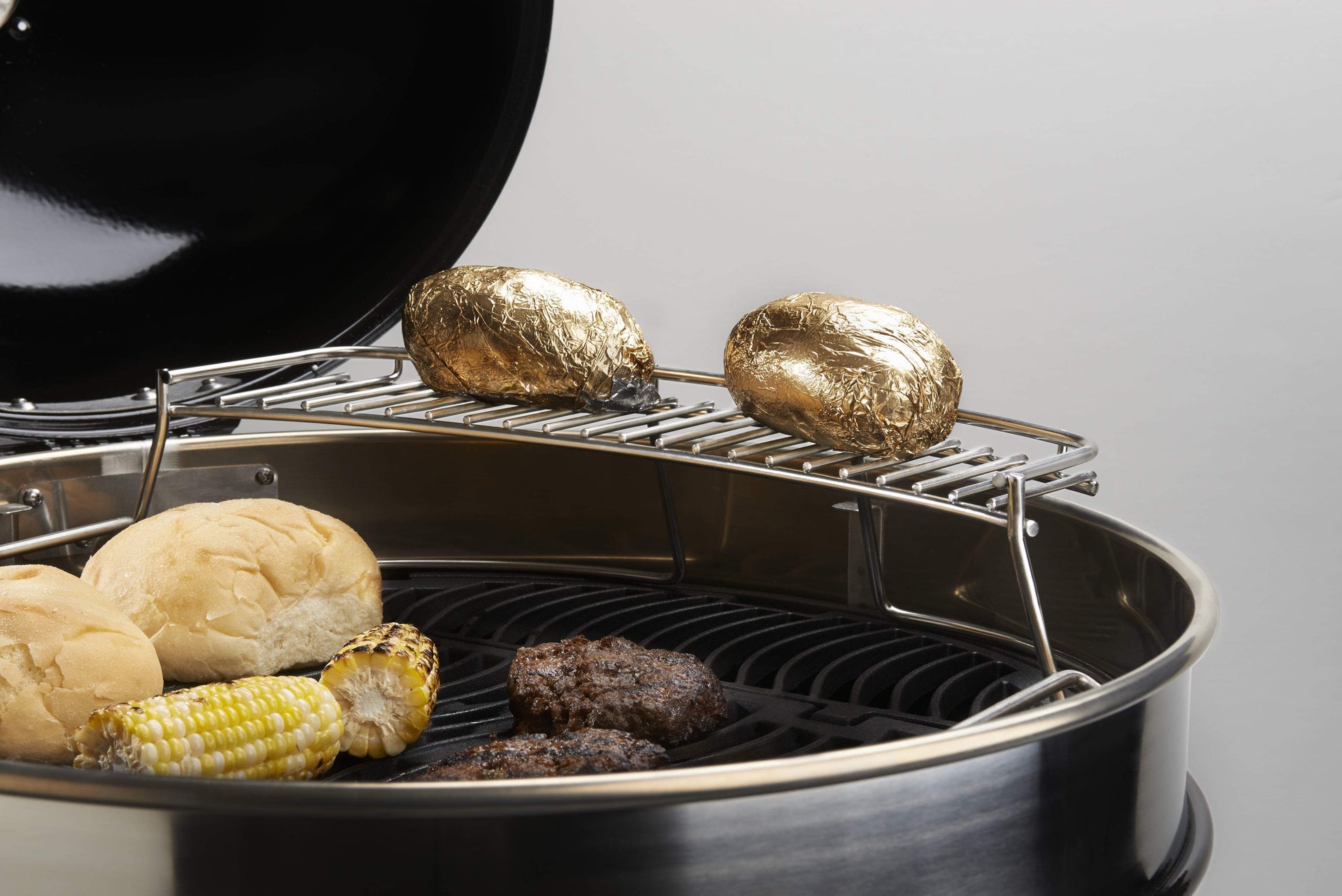 Warming rack over grill, holding chicken and corn on the cob