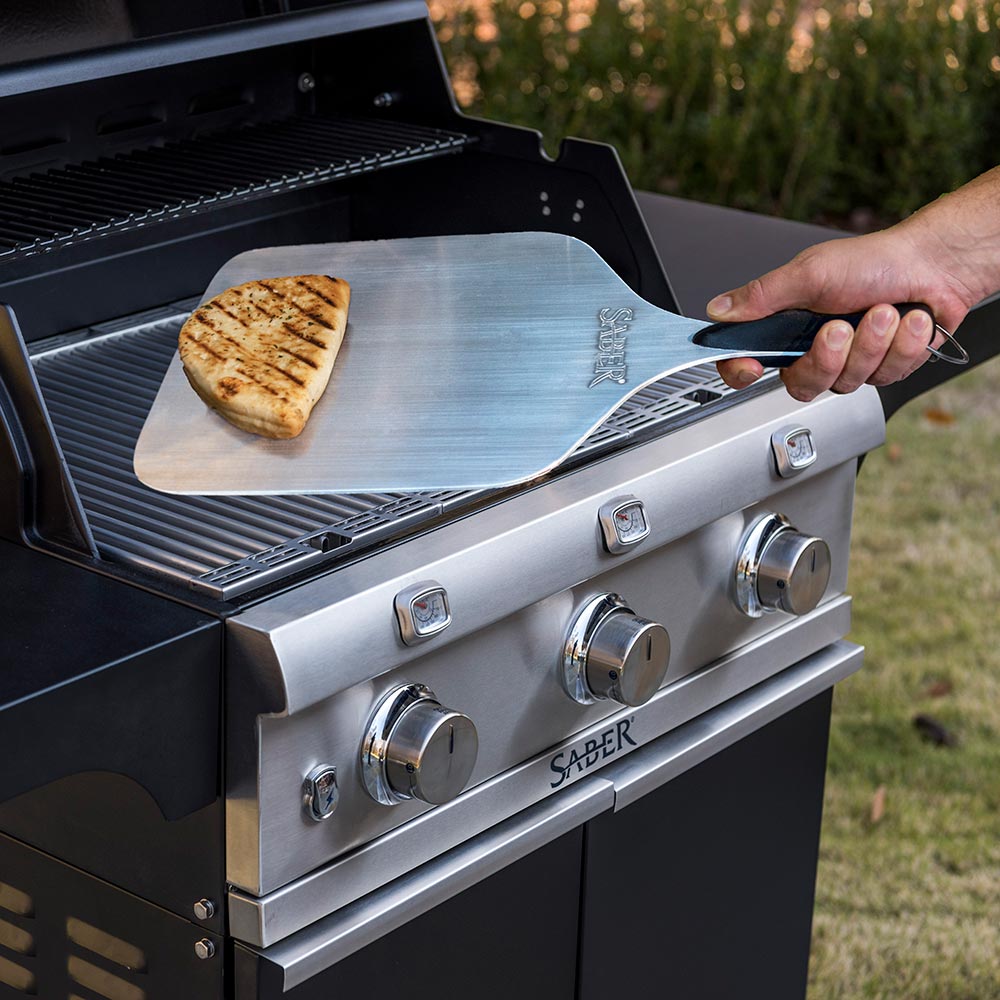 Aluminum pizza peel holding a toasted bread slice