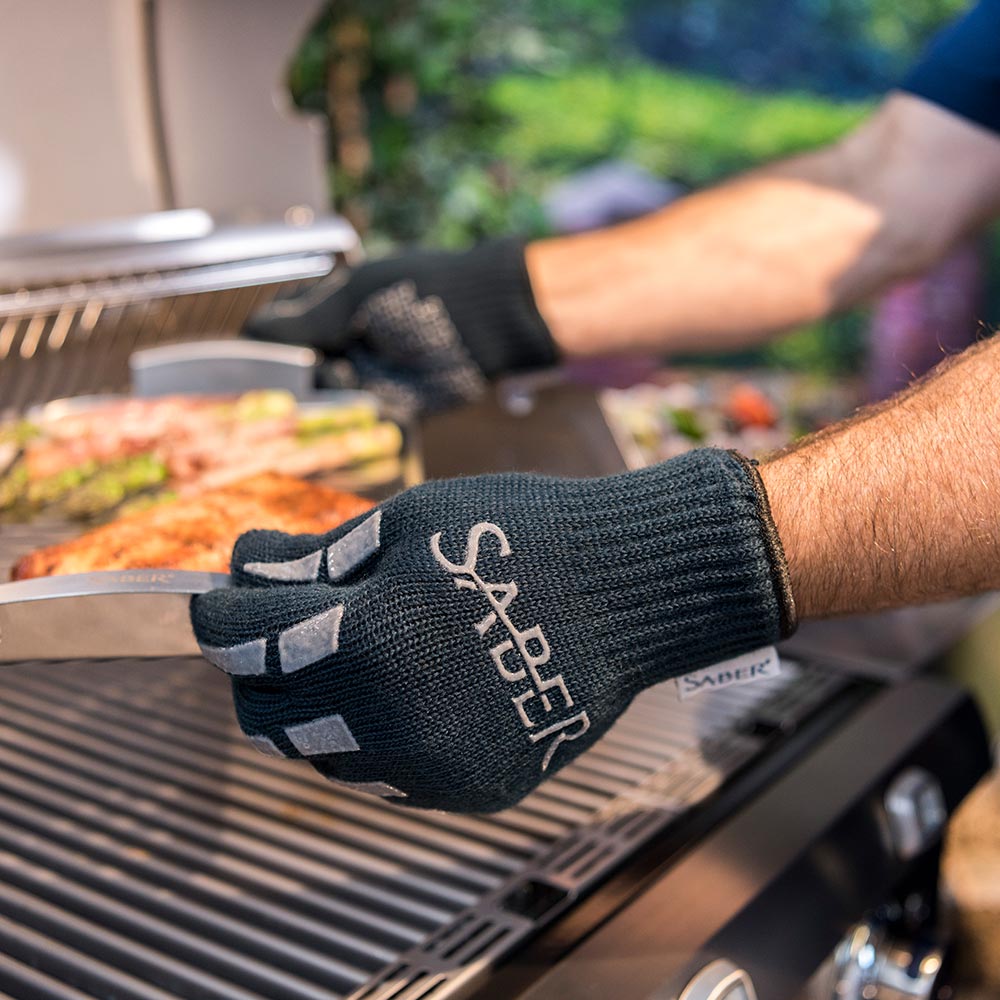 Hand in dark navy grill glove with white Saber logo on back and cutout grips