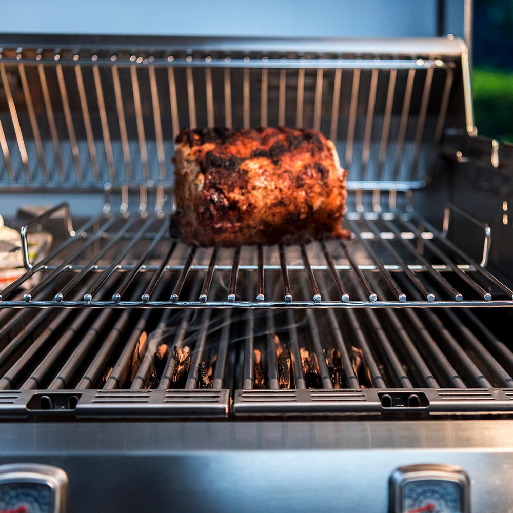 Roasting rack wire grate holding a whole roasted piece on grill bars