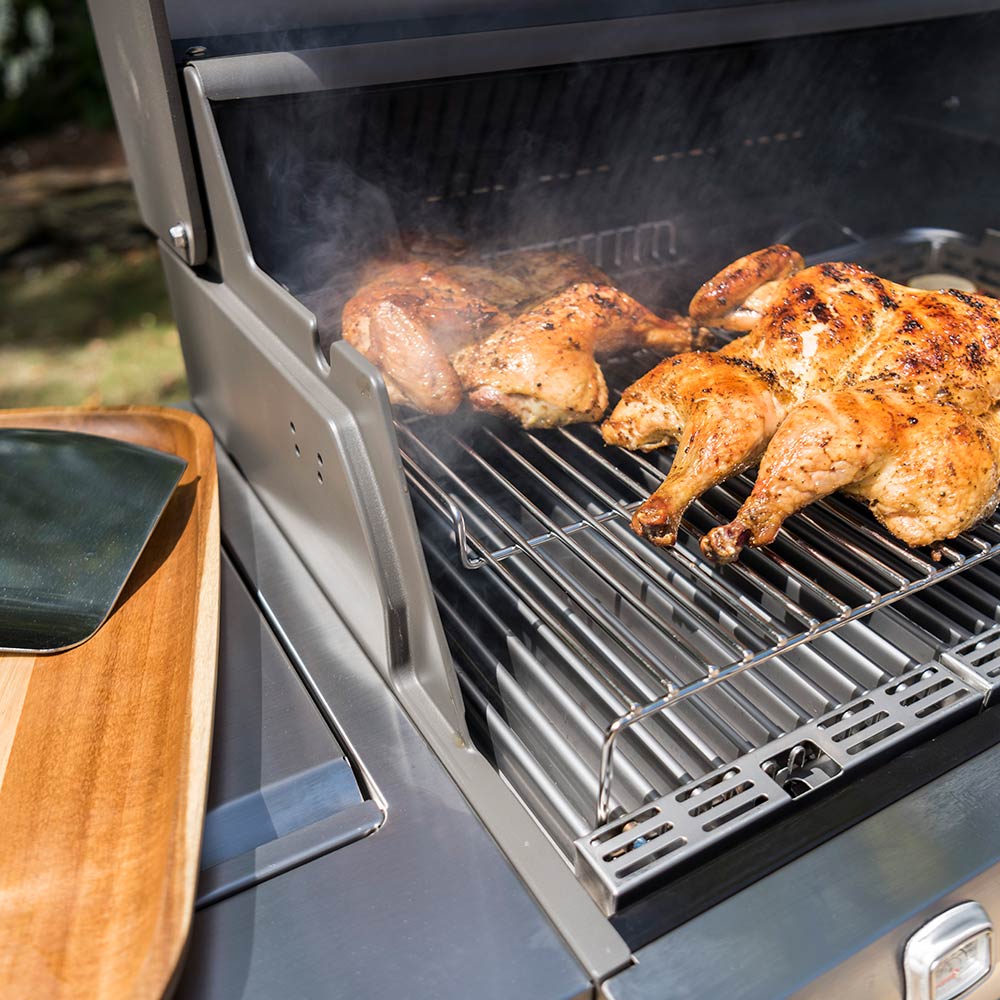 Roasting rack wire grate on open grill with roasted chicken pieces