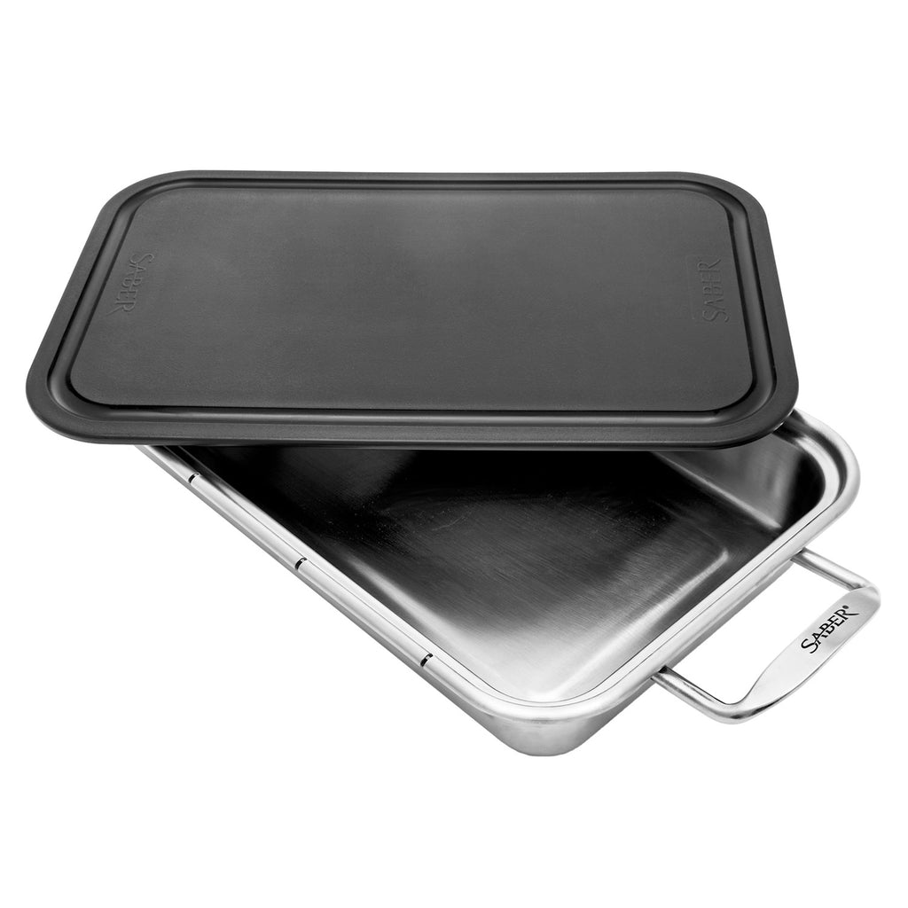 Roasting pan with black lid resting on stainless steel base and hinged-style handles
