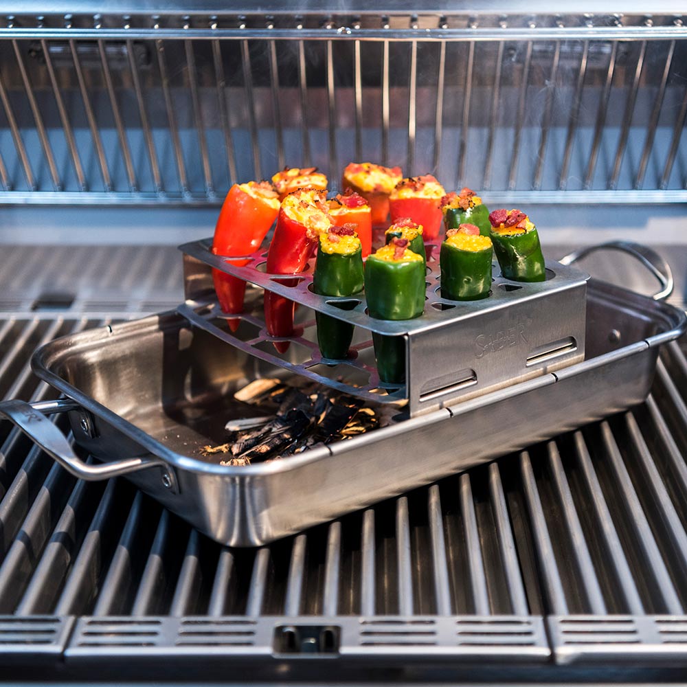 Stainless steel roaster rack with multiple red and green stuffed peppers