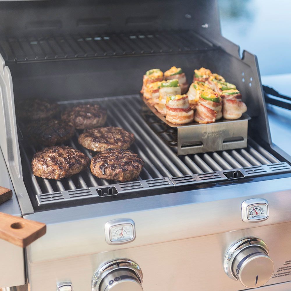 Double pepper roaster tray on grill holding stuffed bites and burger patties