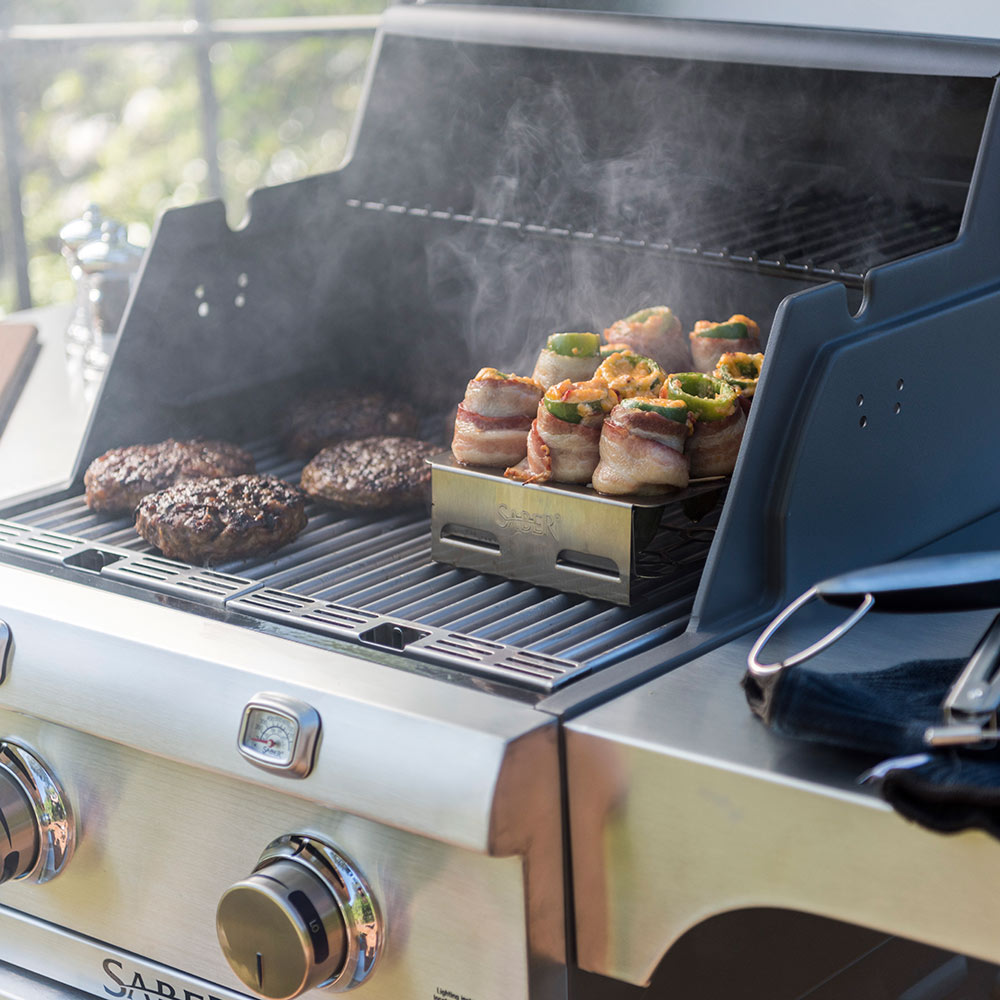 Double pepper roaster tray on grill holding stuffed bites in side rack