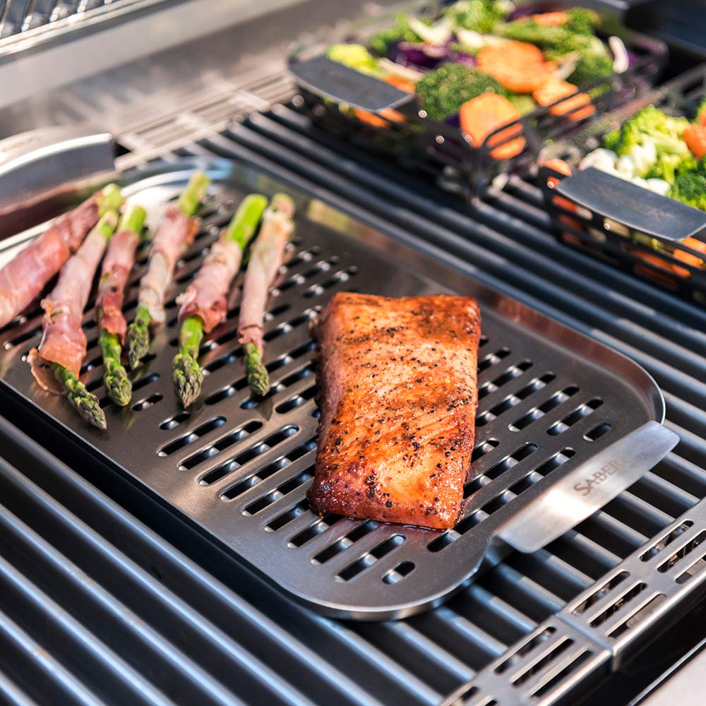 Grill plate with seasoned salmon fillet on raised grate