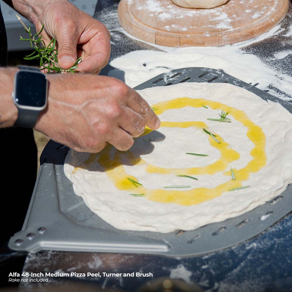 Hands using Alfa pizza peel to slide a flour-dusted dough round