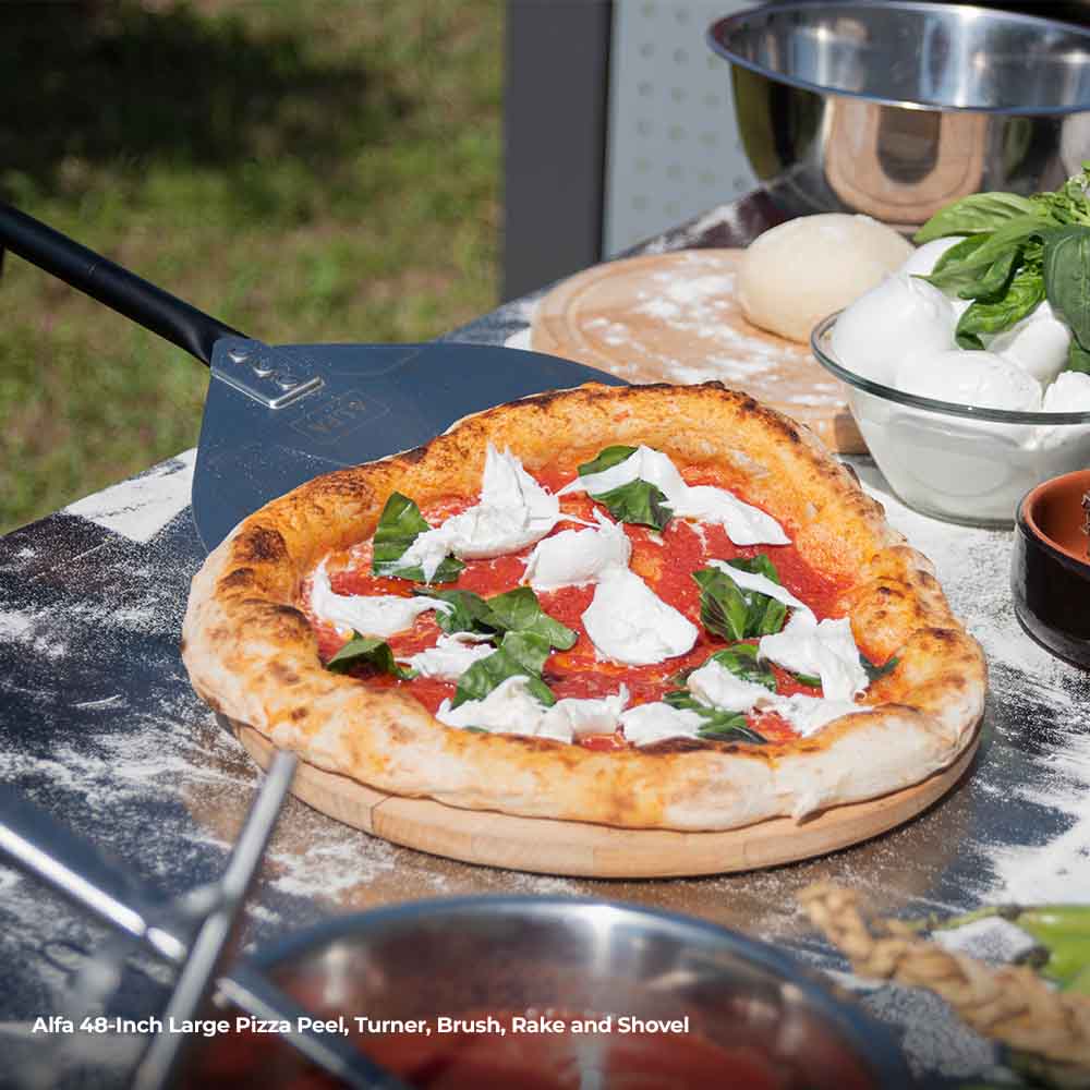 Large pizza peel with long black handle holding topped pizza