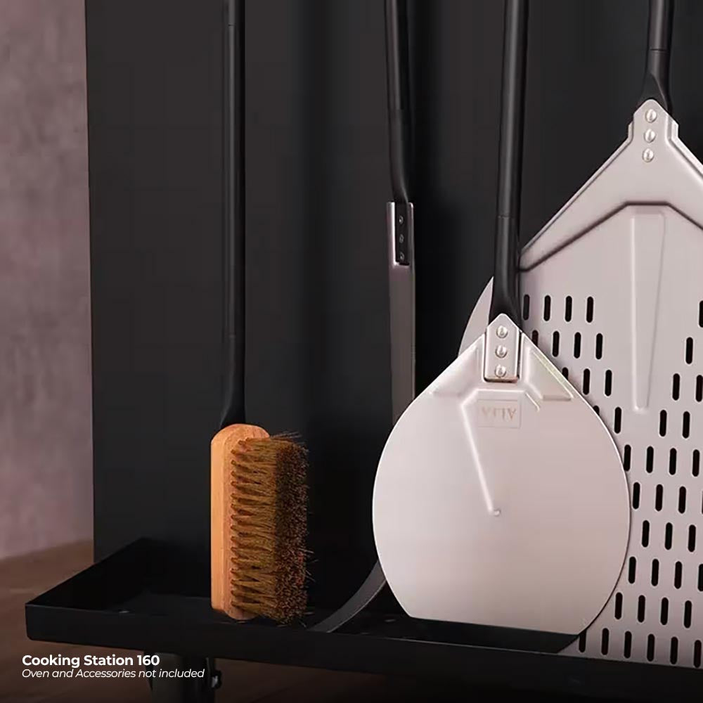 Outdoor cooking station with oven tools, white pizza peel, and sponge pad
