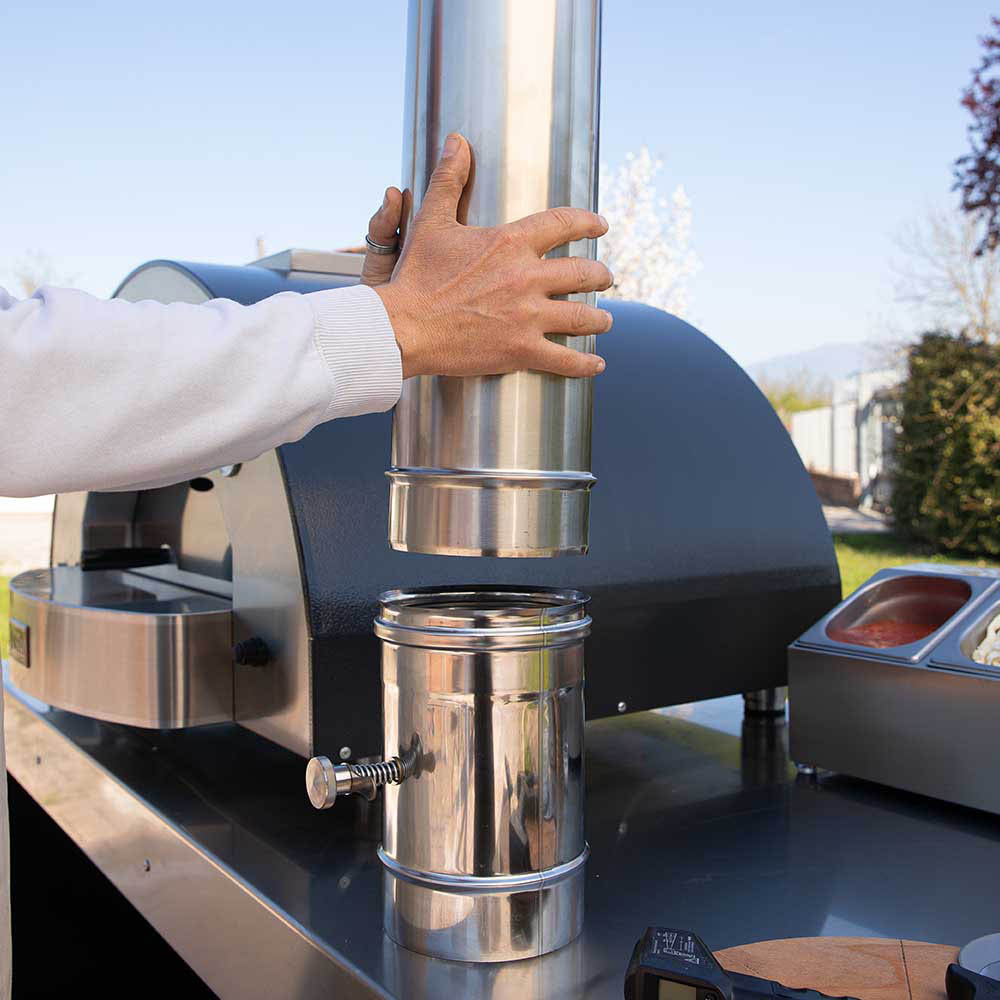 Stainless steel chimney extension on pizza oven with person adjusting