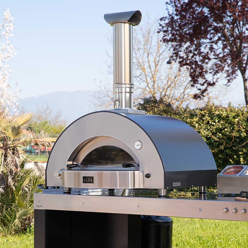 Outdoor stainless steel pizza oven with domed cooking chamber and chimney stack