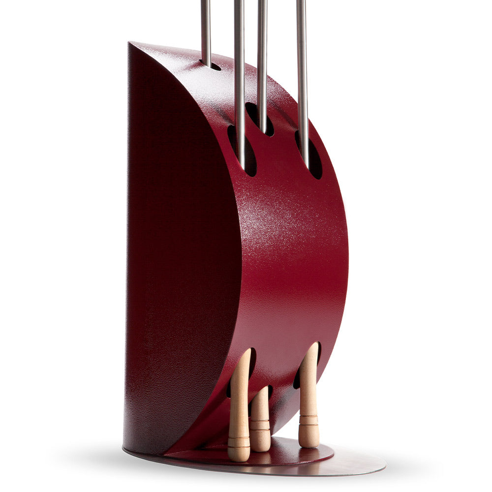 Ruby red metal pizza peel holder with open slots and three wooden handle peels.