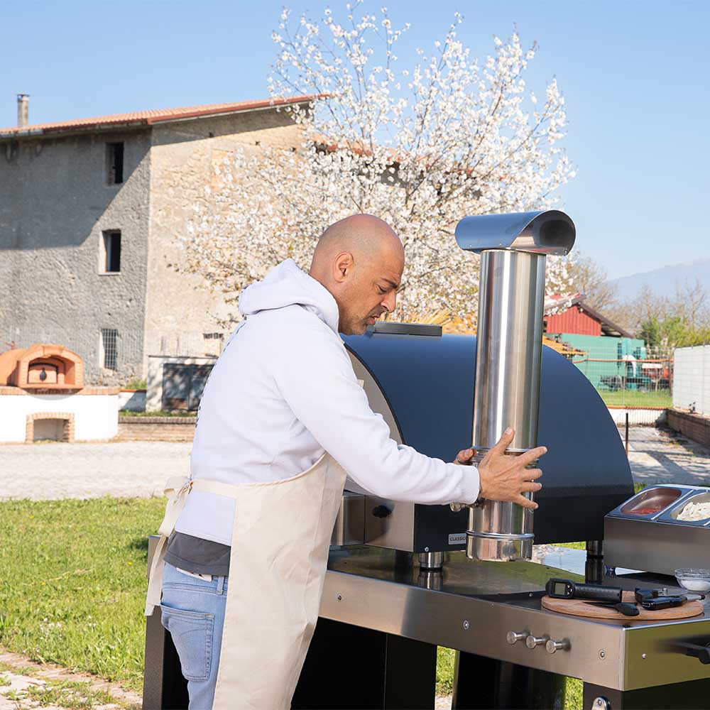 Stainless steel chimney flue with damper valve section at front of outdoor pizza oven