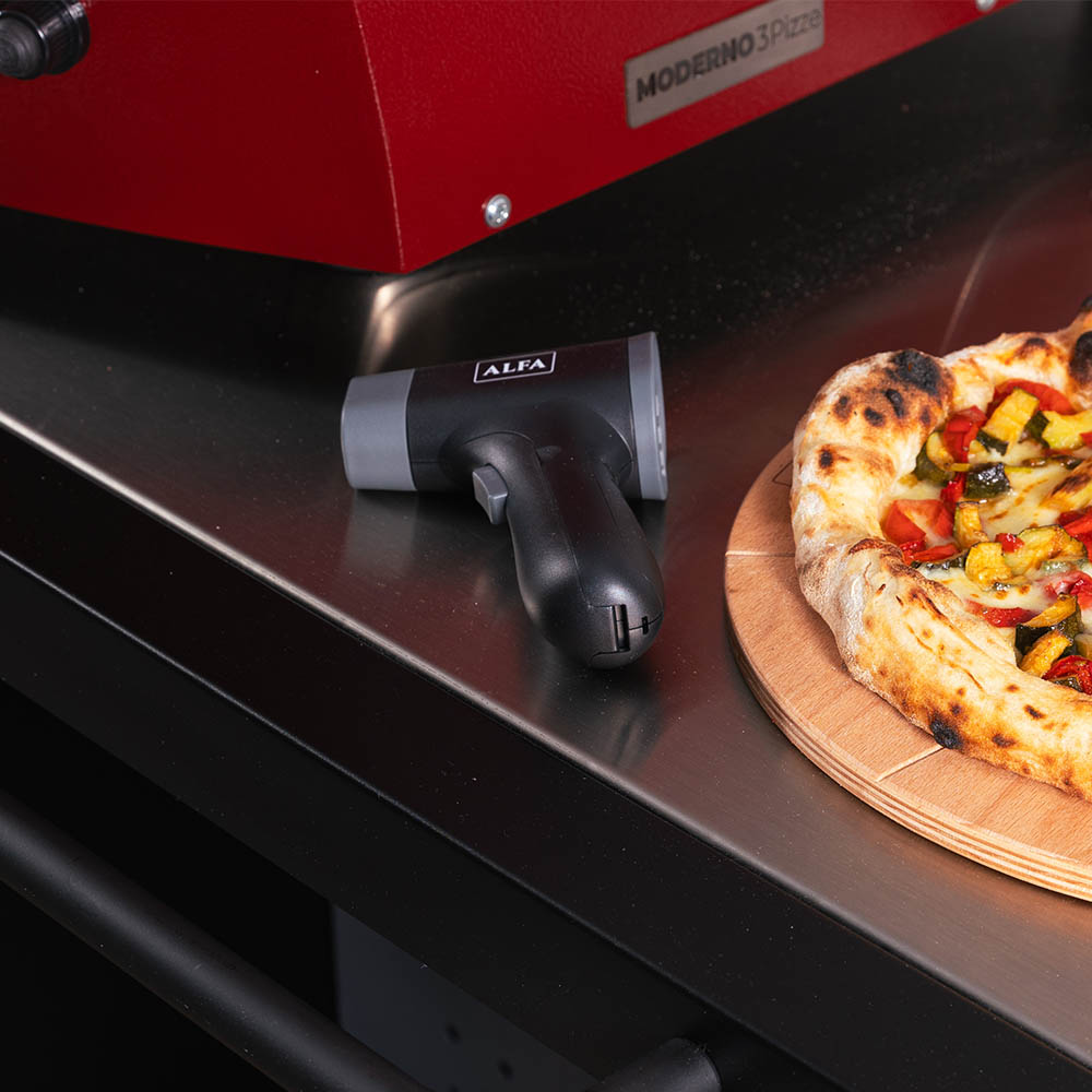 Black laser thermometer with grip handle and LCD display, lying on surface