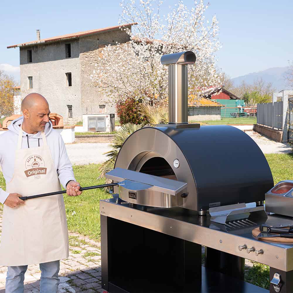 Alfa wood-fired pizza oven with chimney and stainless steel cooking hood outdoors