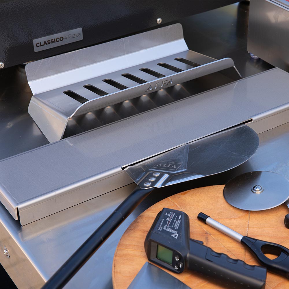 Pizza oven hybrid kit slotted metal insert and blade tool near front of oven