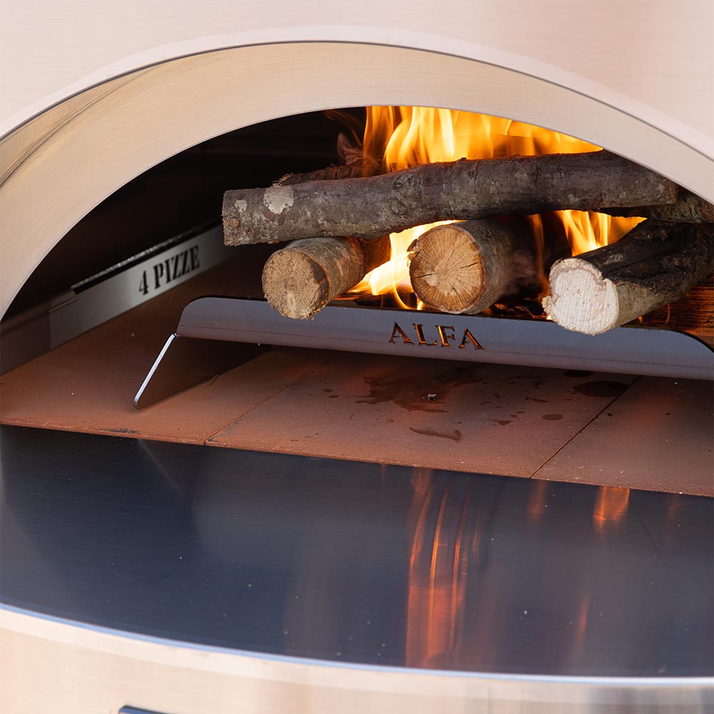Pizza oven firebox with burning logs and flames behind the cooking floor