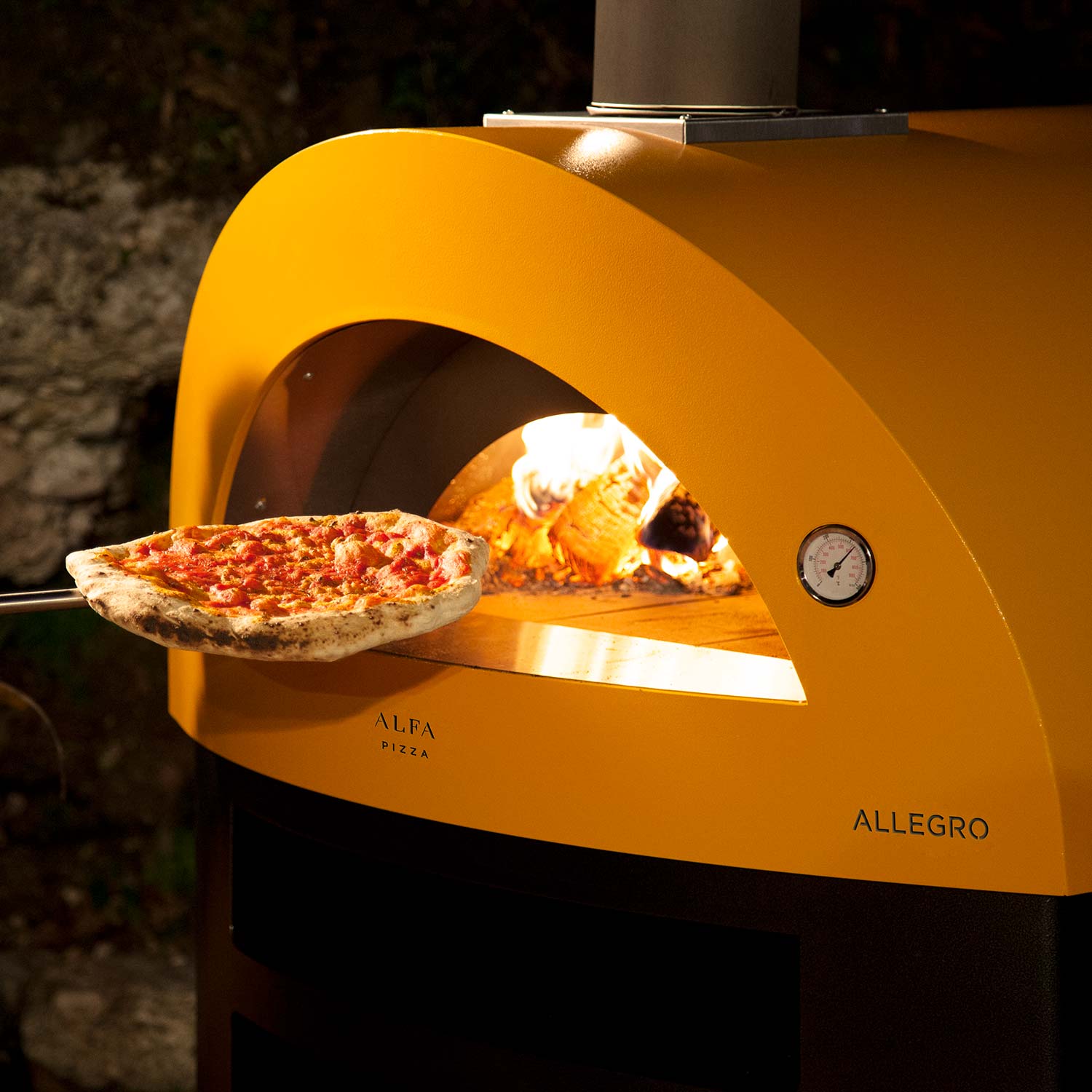 Yellow countertop wood-fired pizza oven with pizza on stone and flames inside