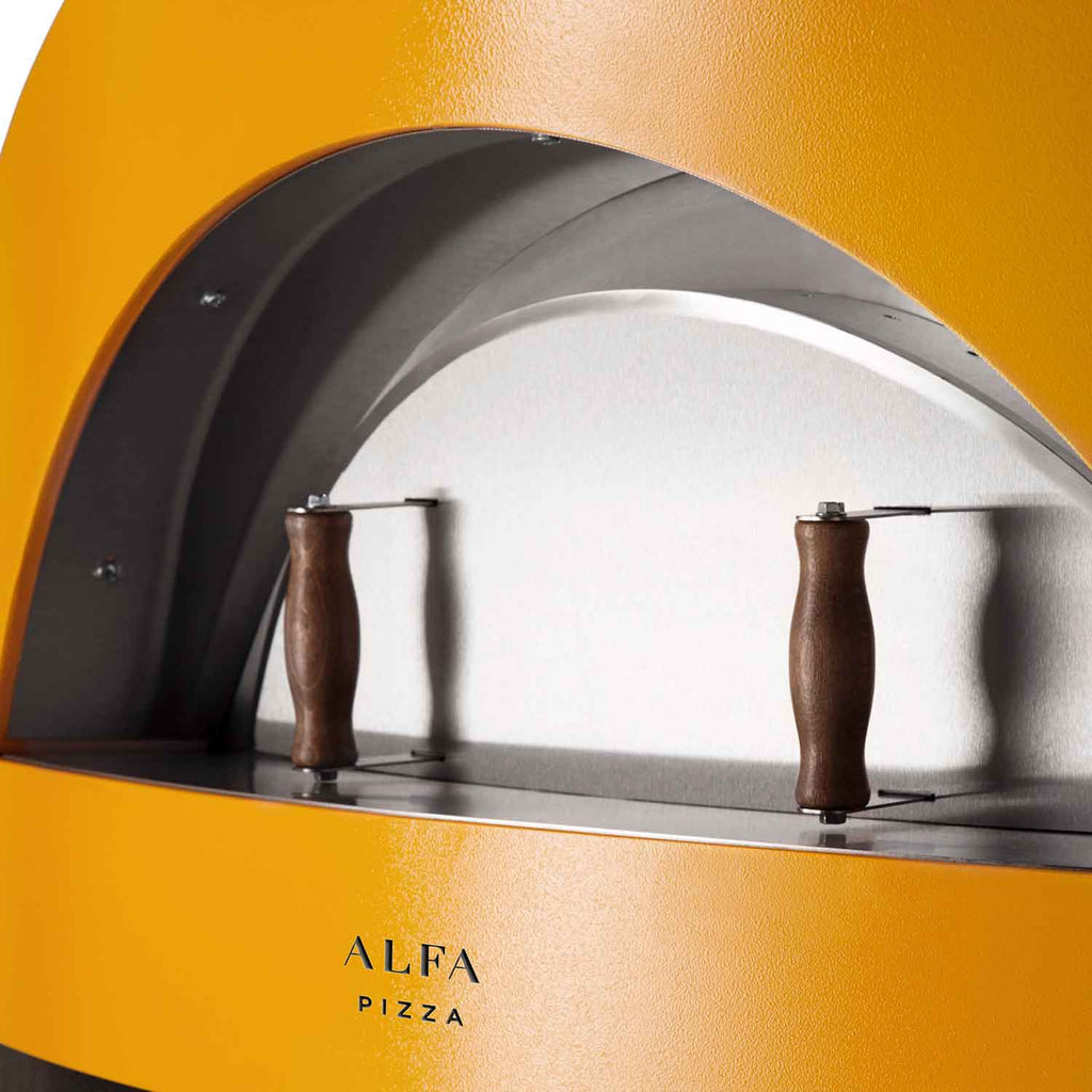 Yellow oven cooking chamber with arched front and two brown-handled tools
