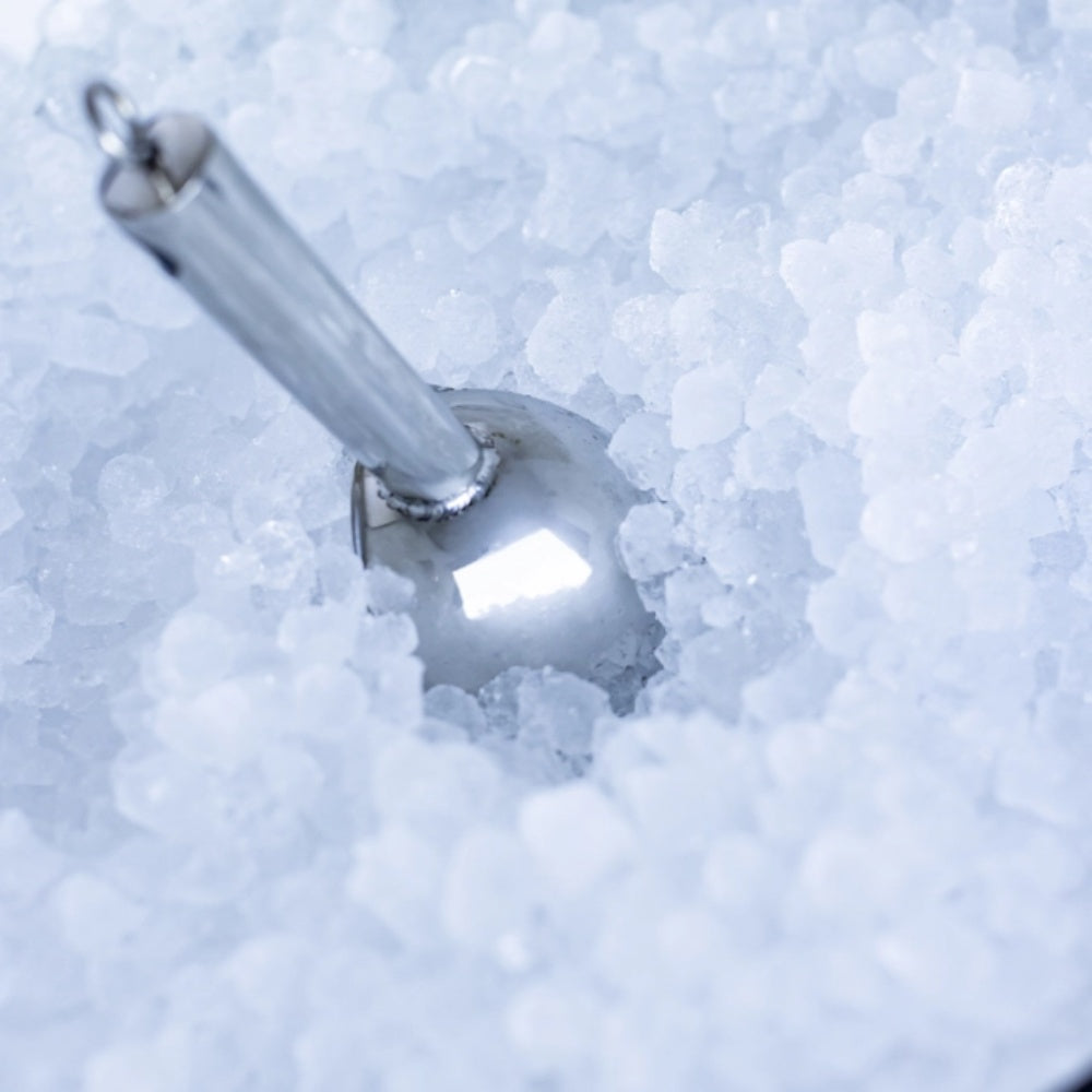 Nugget ice cubes in the bin with a metal scoop