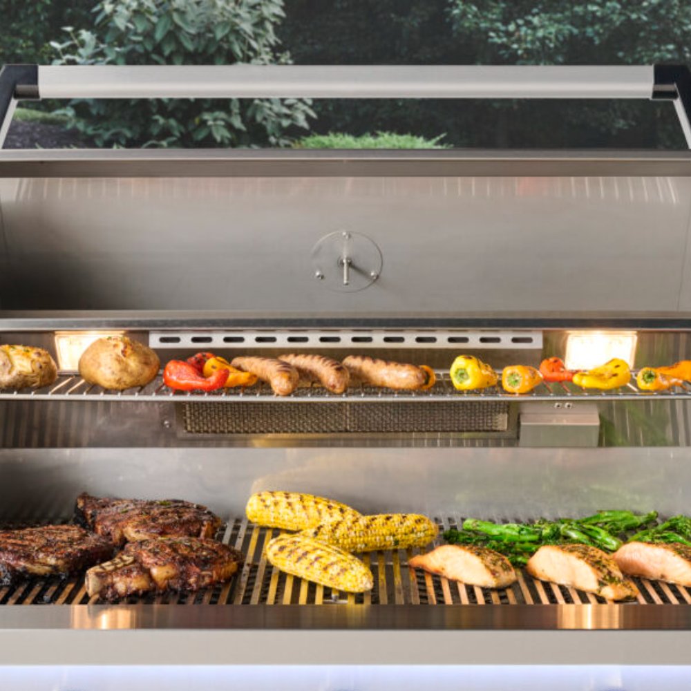 Open built-in gas grill with cooked food on grates and vegetables