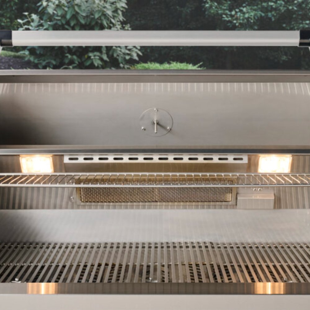 Built-in gas grill interior with open hood, grates, and warming area tray