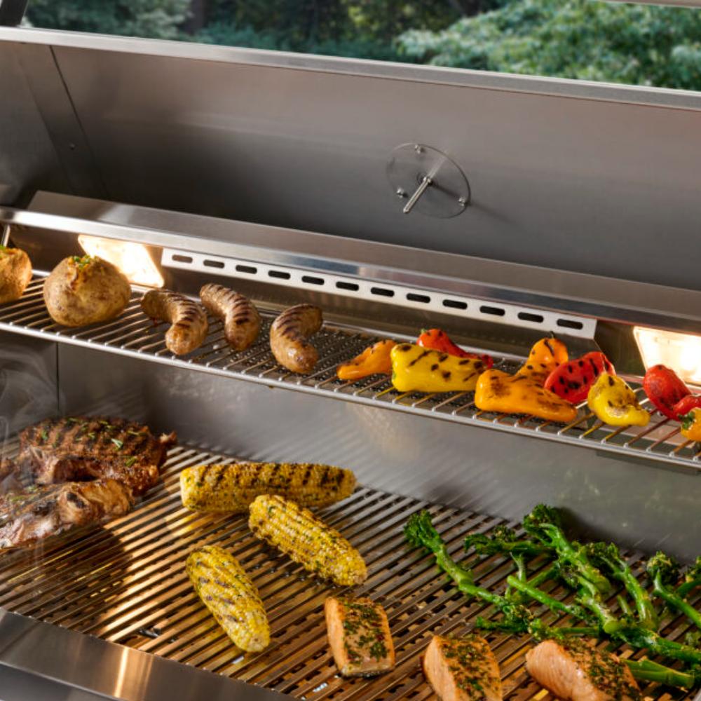 Built-in gas grill interior with searing food, vegetables, and open lid