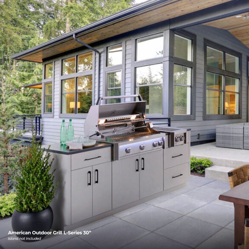 Stainless outdoor gas grill with open lid and four control knobs on built-in base