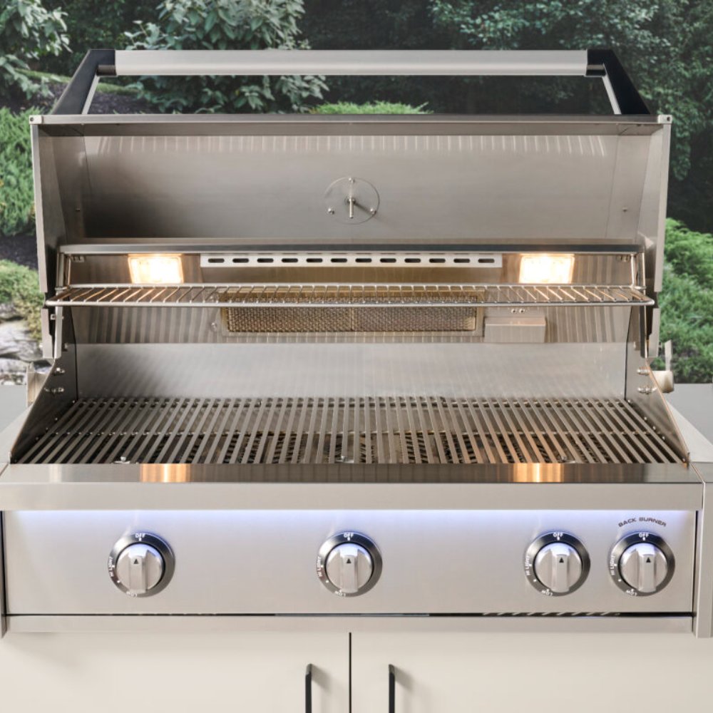 Stainless gas grill with open hood, illuminated burners, and empty warming rack below