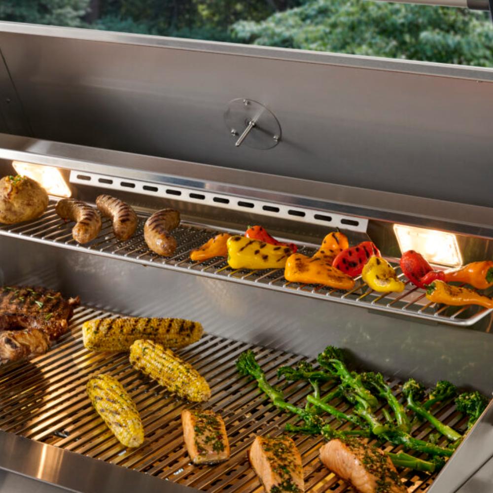 Open gas grill with metal grates and grilling peppers, corn, and sausages