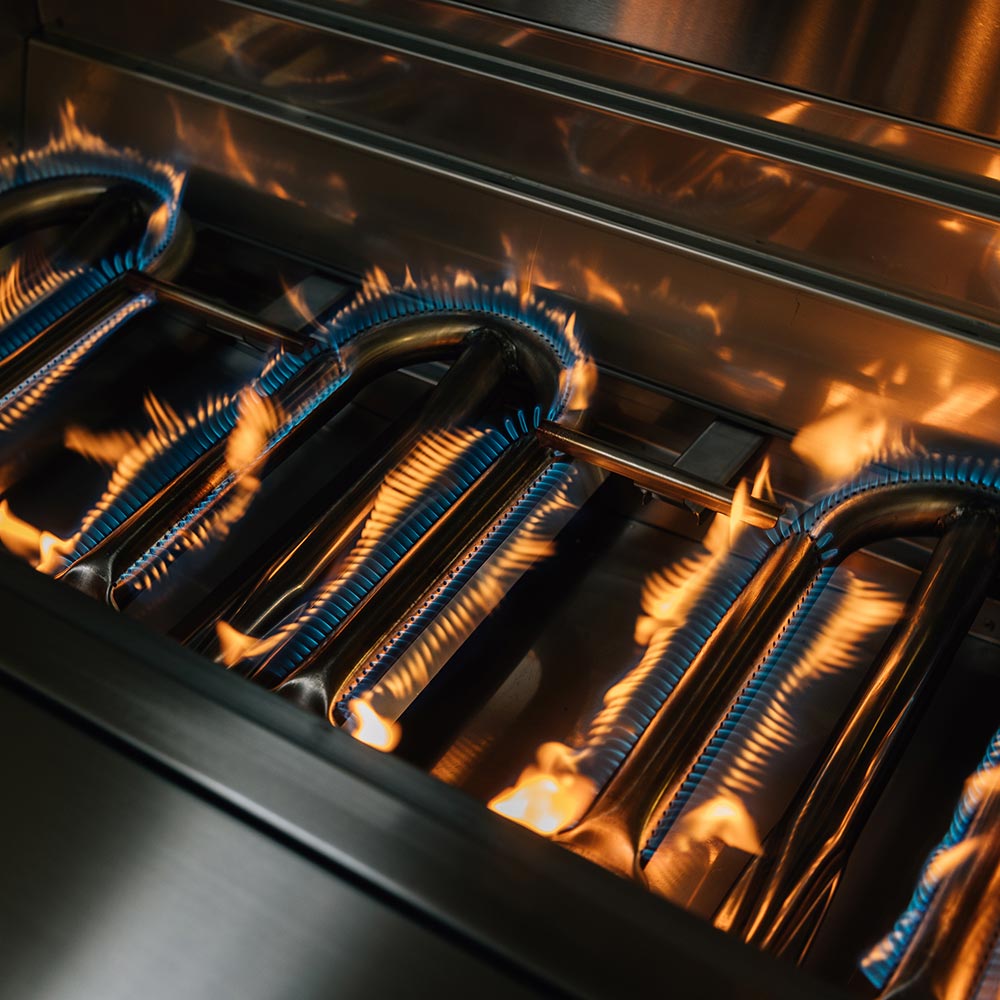 Gas grill burners with steady blue flames and orange fire below the cooking surface