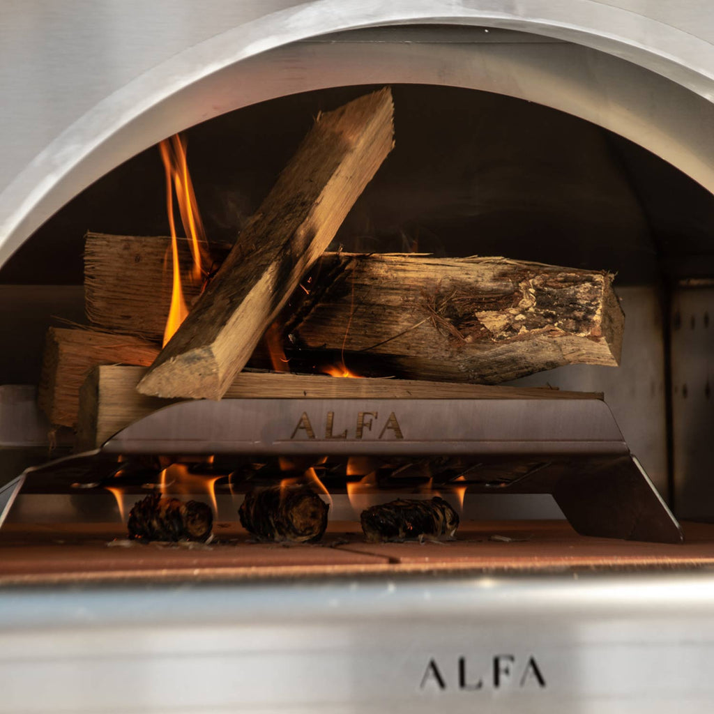 Wood-fired pizza oven interior with stacked logs and glowing fire on the base