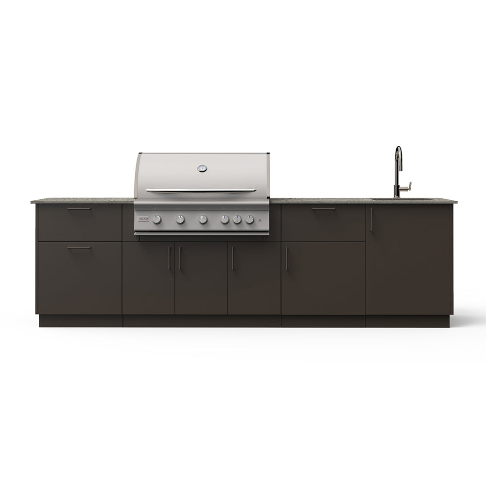 Outdoor kitchen island with built-in grill, faucet, and sink, dark cabinetry and light countertop.