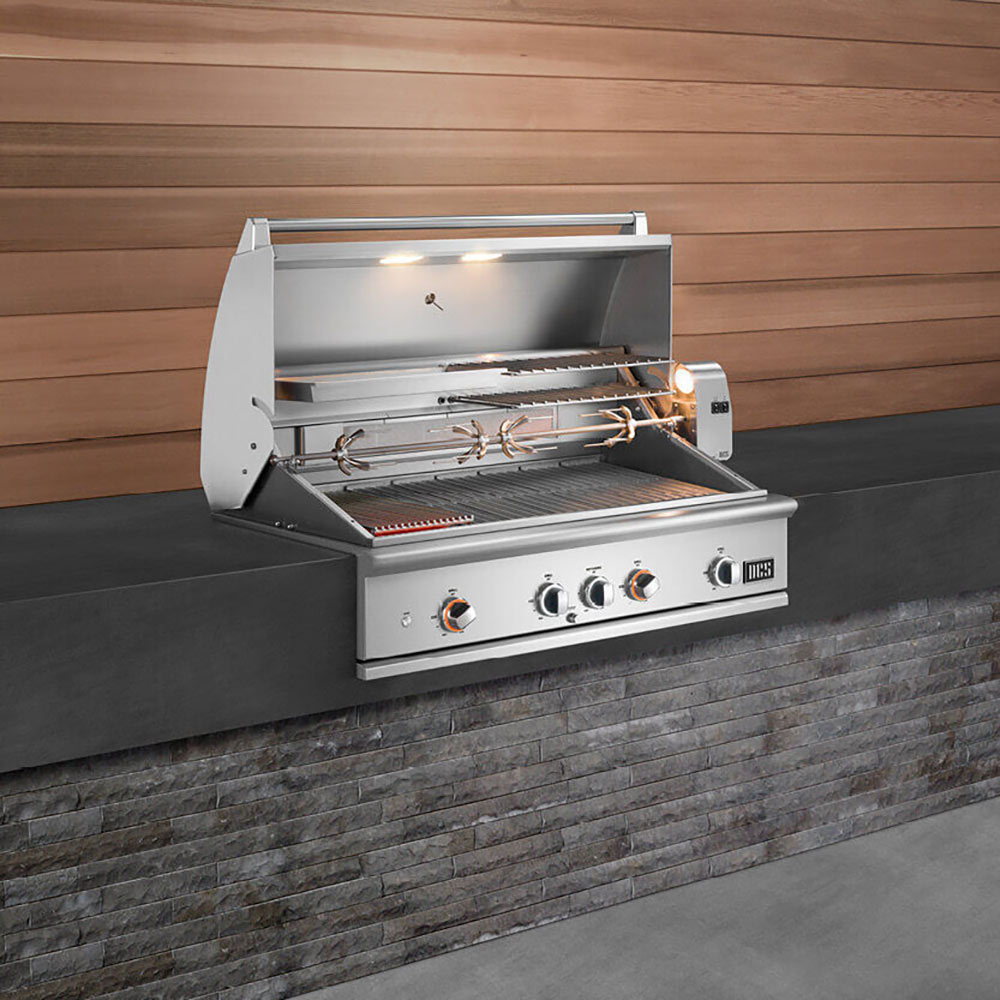 Built-in gas grill with open hood, rotisserie spit and grill grates inside