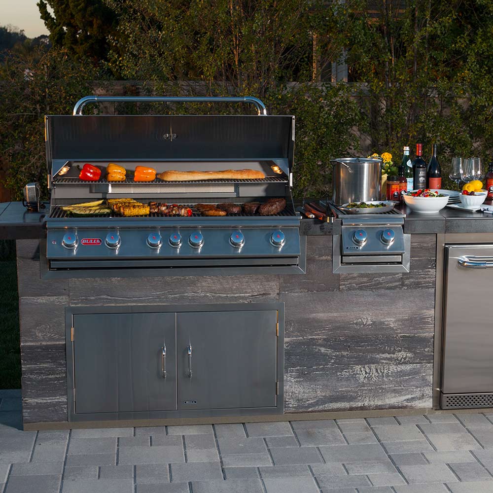 Bull 46-inch 6-burner built-in gas grill with lit cooking area and open hood