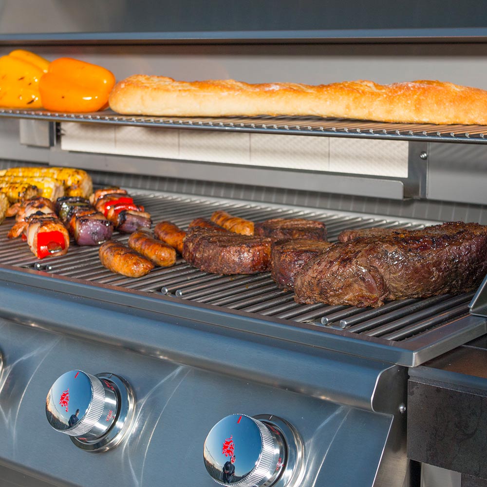 Bull 6-burner grill grates with seared meats and sausages, lid open