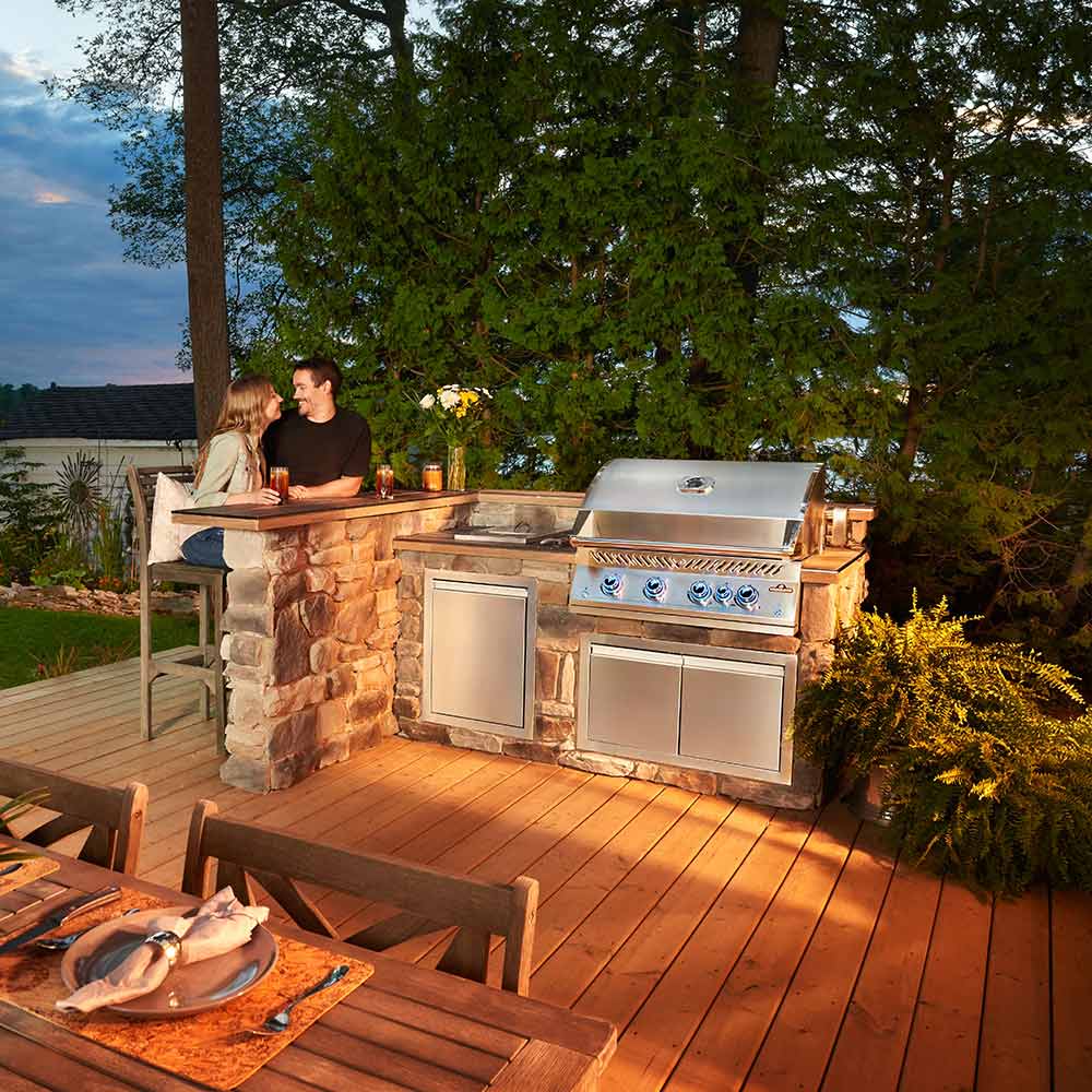 Stainless steel built-in gas grill with side doors, control knobs, and side shelf
