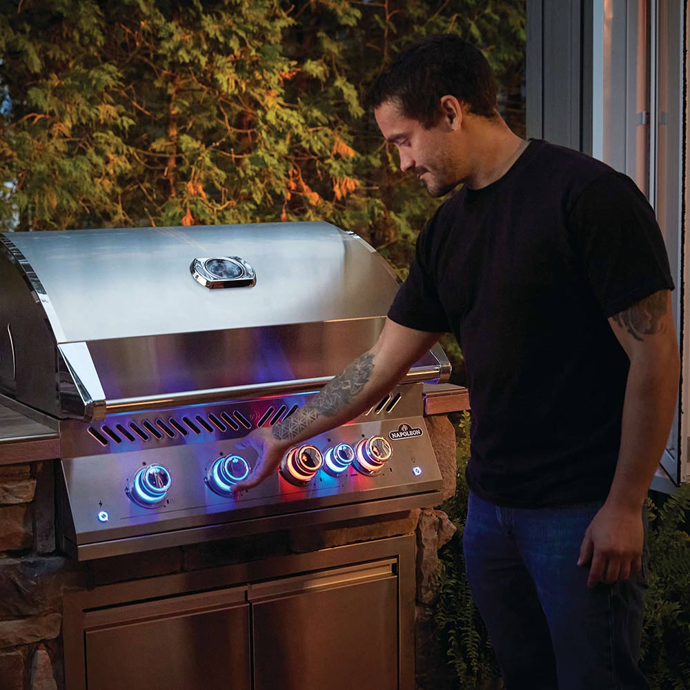 Stainless steel 4-burner grill head with glowing blue controls and closed lid