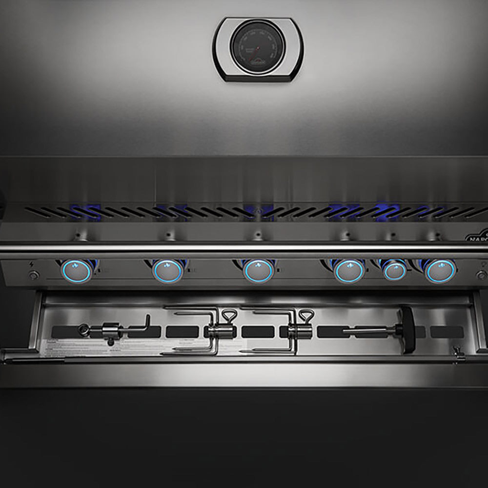 Stainless steel gas grill burner area with vent slots and glowing blue ignition