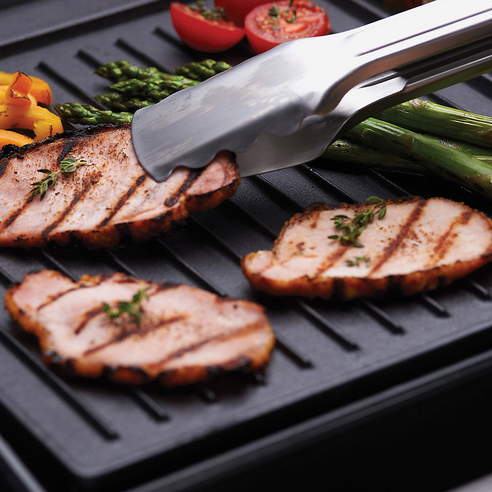 Cast iron griddle with grilled slices and a spatula lifting food